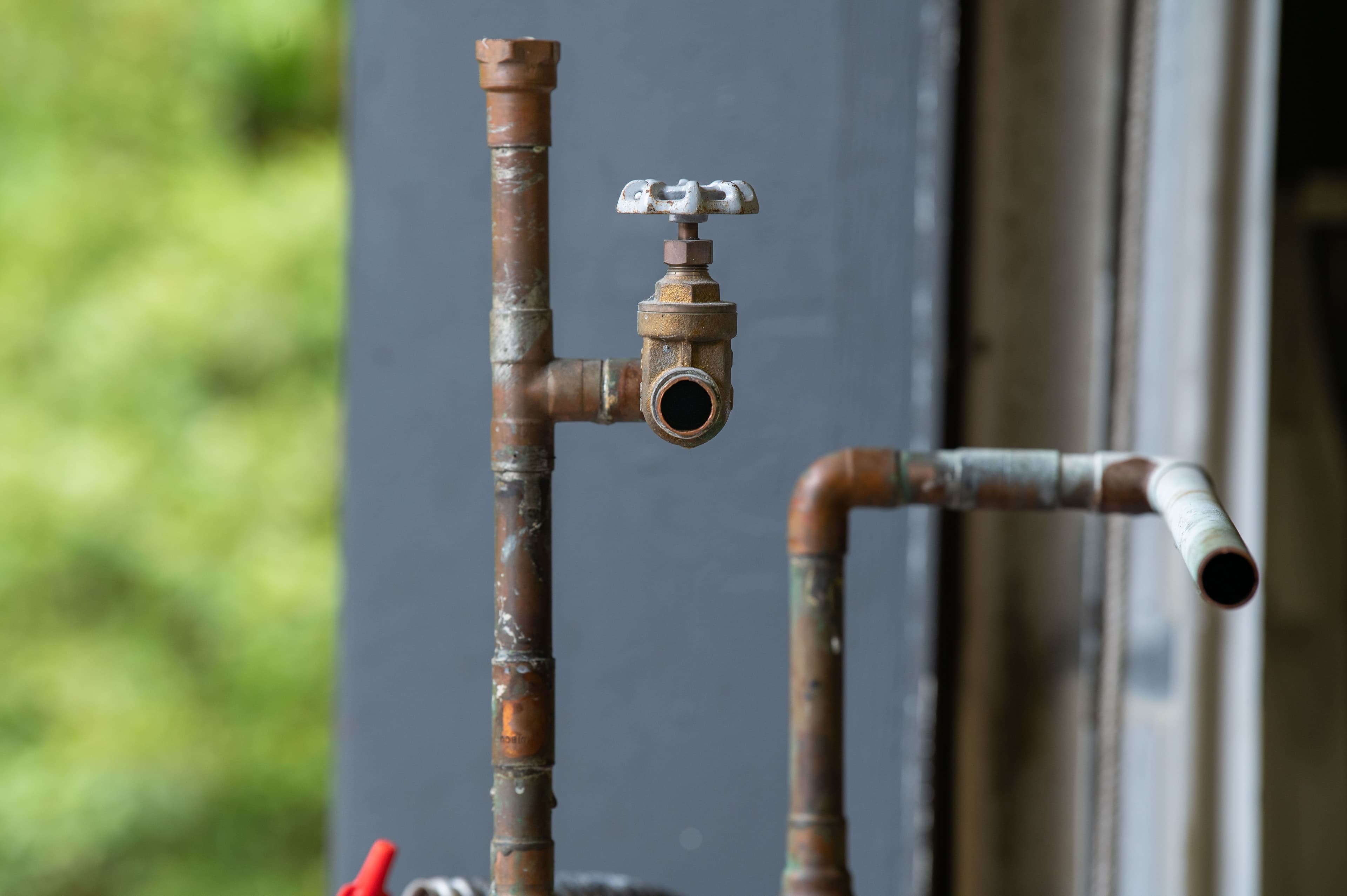Weathered copper water pipes with an exposed valve
